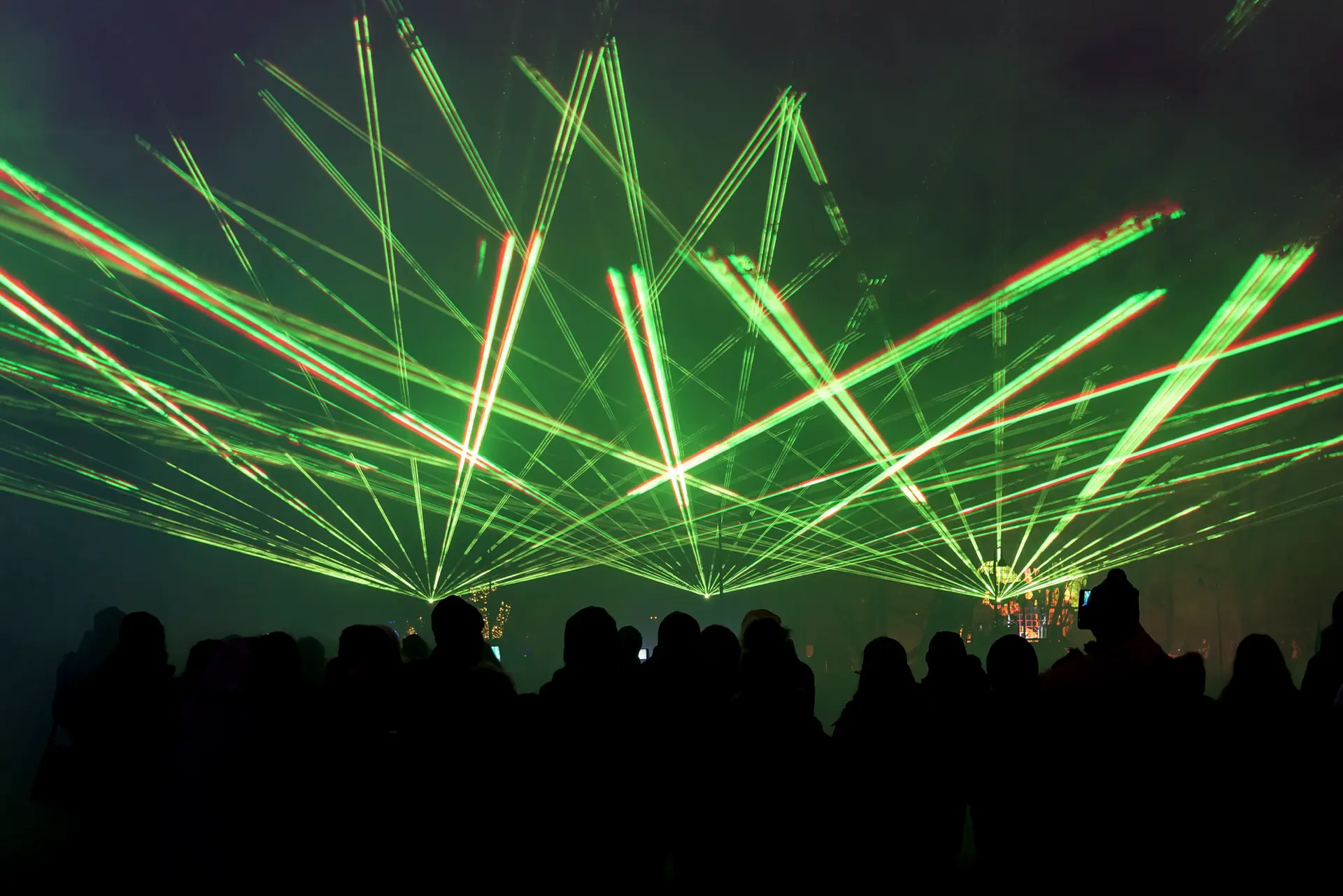 Grüne Laserstrahlen über dem Publikum einer Veranstaltung