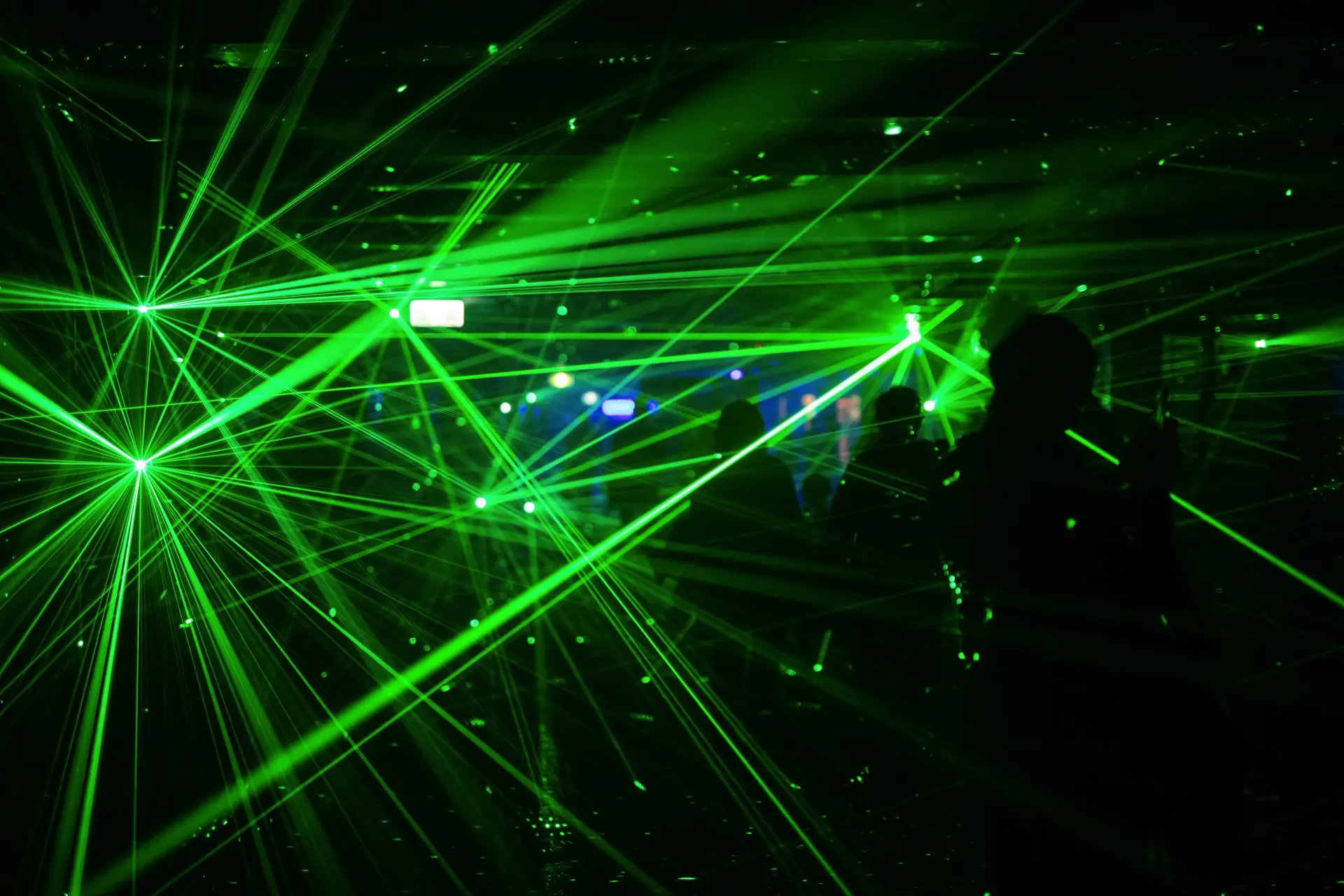 Grüne Laserstrahlen bei einer Bühnenshow mit Publikum
